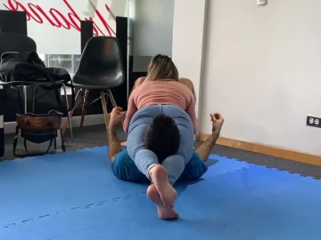 woman does headscissor challenge at the gym