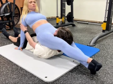 fitness instructor flexes her scissorhold leg strength